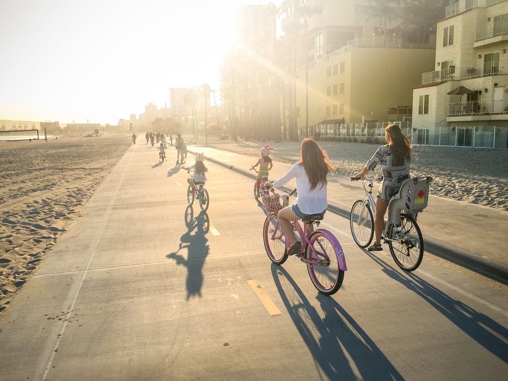 A group of children biking near the shore of Long Beach, CA